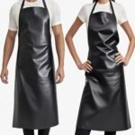 Two models wearing long black waterproof dyeing aprons over white shirts against a white background.